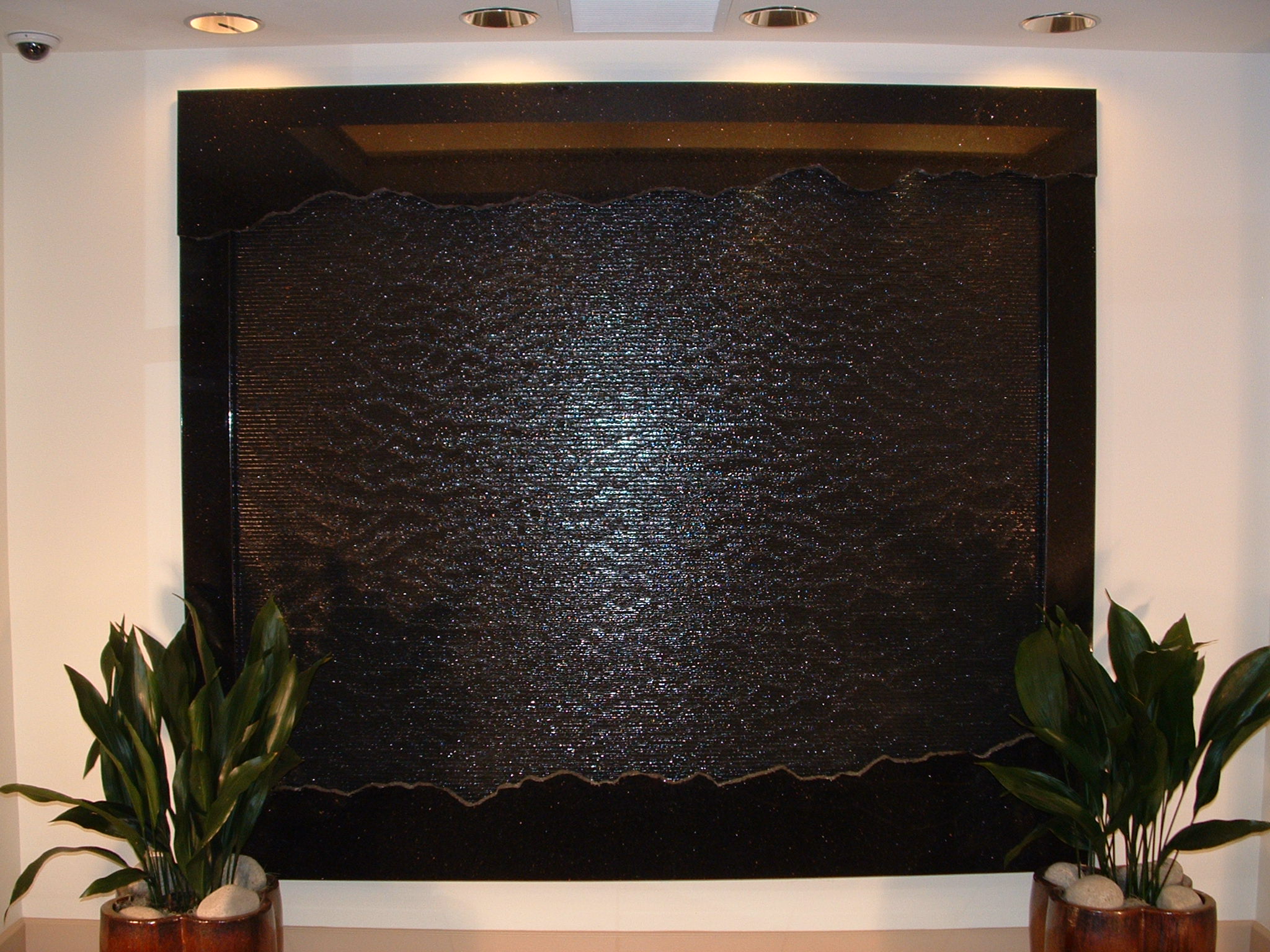 Lynnwood, WA. CRS financial institution foyer. 9ft x 7ft tall black granite wave wall with fractured valance and basin front, polished bull nose vertical side rails, wall hung 2,000 lb., lighting within valance, remote resiver location, and auto filler, new construction
