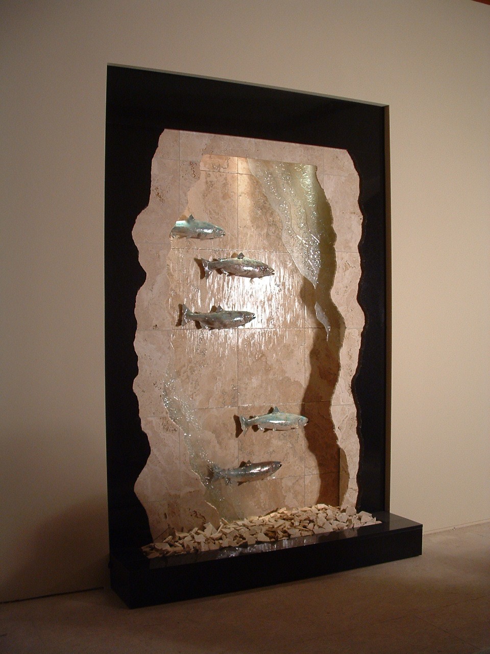 Try City, WA. residence. 7 ft x 10 ft tall travertine backdrop and fractured face with black granite fracture overlaid, fracture art glass in the mix 5 racue glazed salmon, lighting in valance broken travertine in basin, remote pump location. New construction, auto filler.