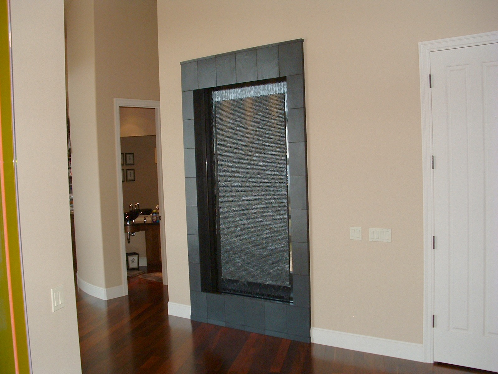 Issaquah WA. residence. 6 ft x 9 ft tall. Black granite wave wall back drop with polished perimeter black slate framework, lighting in valance existing home