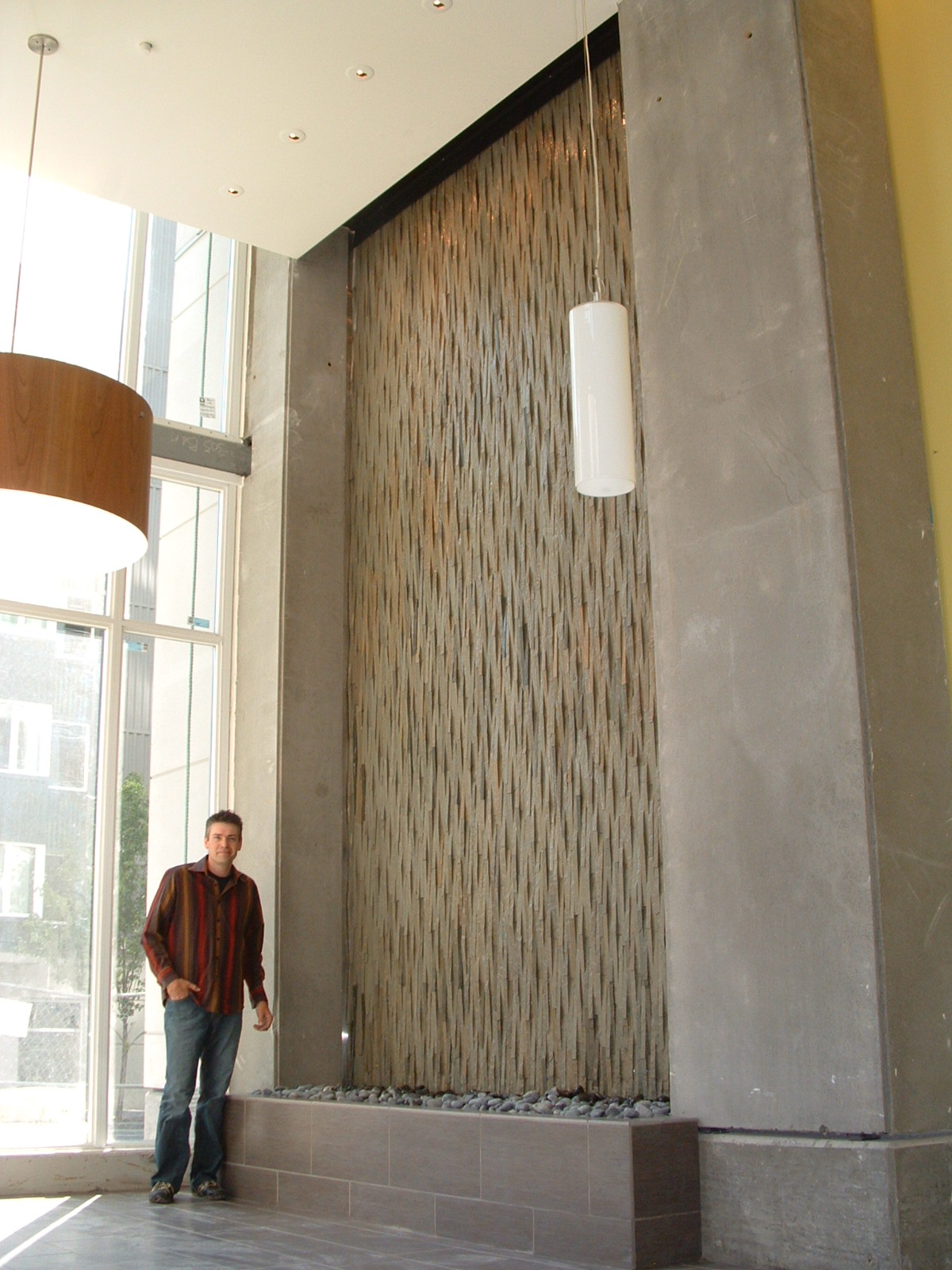 Belltown/Seattle, WA. condo high rise lobby, 10 ft 6 in by 17 ft tall, rustic clad Island stone, weave pattern, auto filler, easy drain, lighting within the valance. 